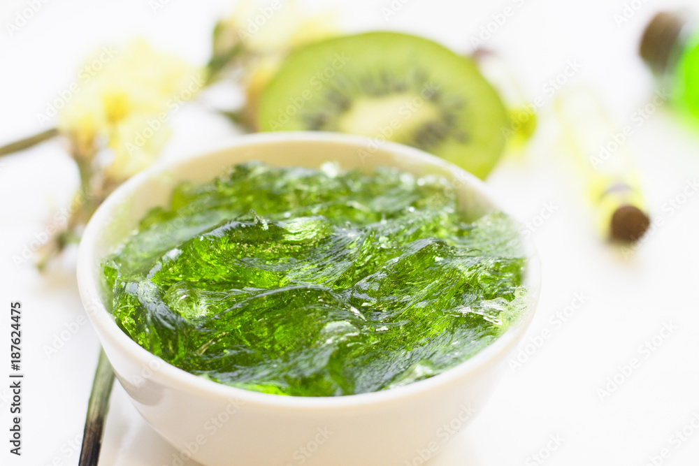 Natural green cosmetics concept. A container of jelly cream soap and kiwi, white background, top view Natural green cosmetics concept. A container of jelly cream soap and kiwi, white background, top view