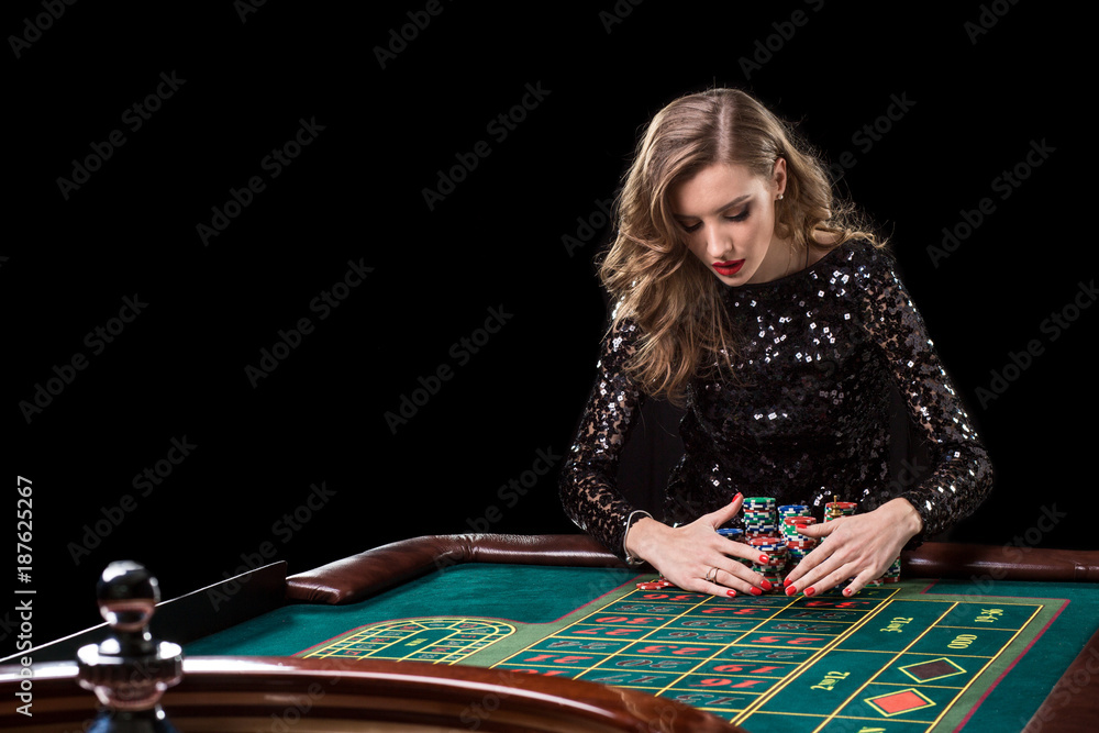 Woman playing in casino. Woman stakes piles of chips playing rou Woman playing in casino. Woman stakes piles of chips playing rou