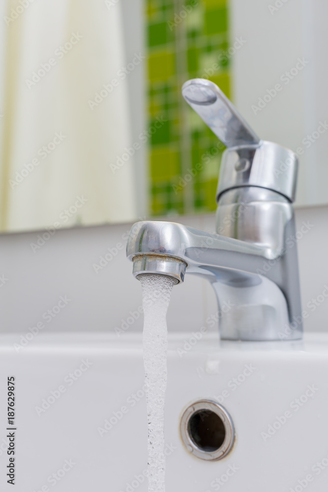 Modern chrome tap faucet with running water. Modern chrome tap faucet with running water.