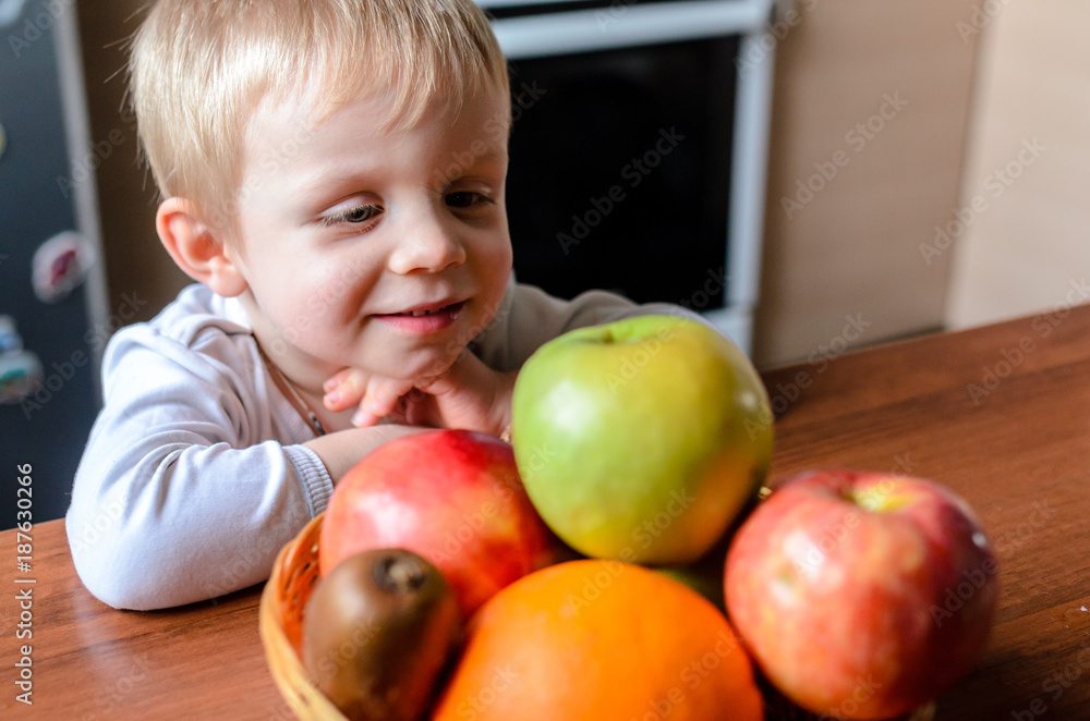 The child looks for fruit and smiles. The child looks for fruit and smiles.