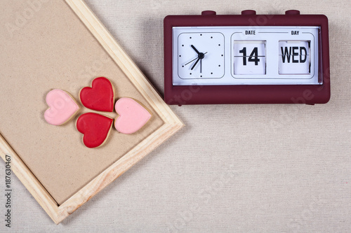 Valentine background pink and red heart cookie with clock calenda on slate blackboard. Ideas for valentine's love concept. photo