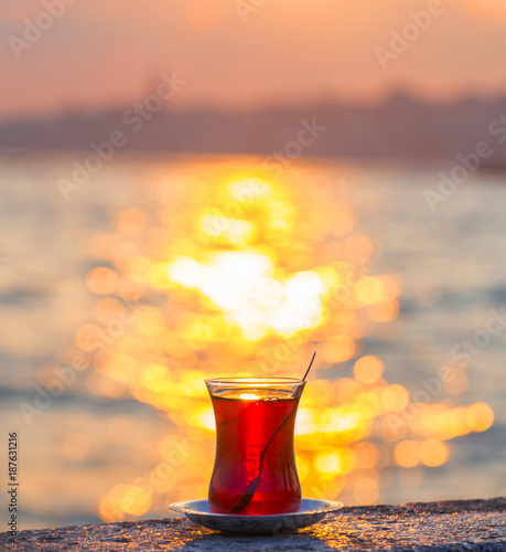 A cup of Turkish tea against the backdrop of the sunset and the Bosporus Strait photo