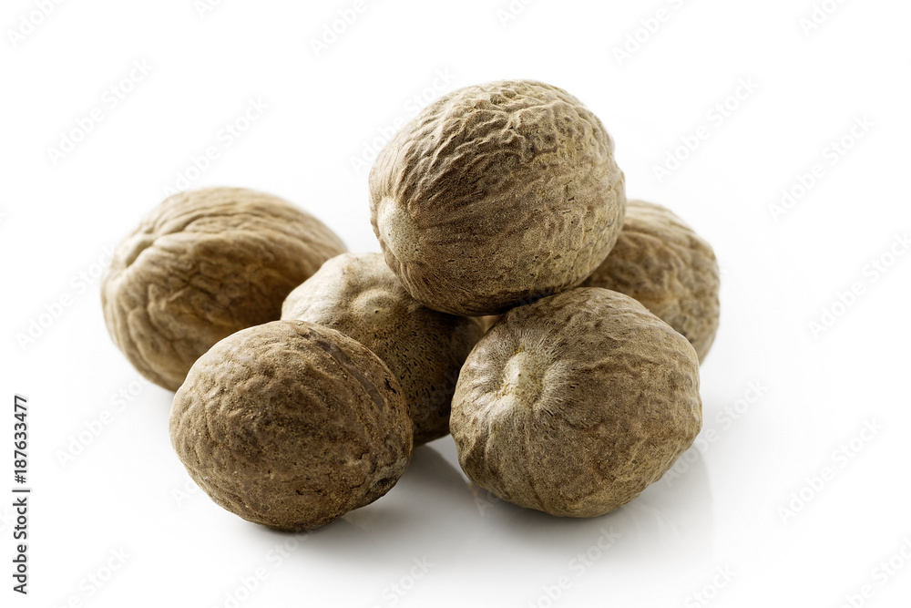 A pile of dried whole nutmegs isolated on white. A pile of dried whole nutmegs isolated on white.