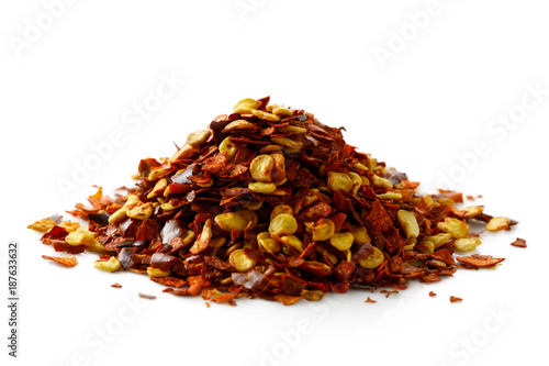 A pile of coarsely ground chilli peppers isolated on white.