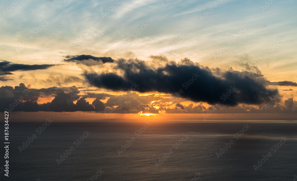 The sun and its last beams during a sunset on an island over the ocean The sun and its last beams during a sunset on an island over the ocean
