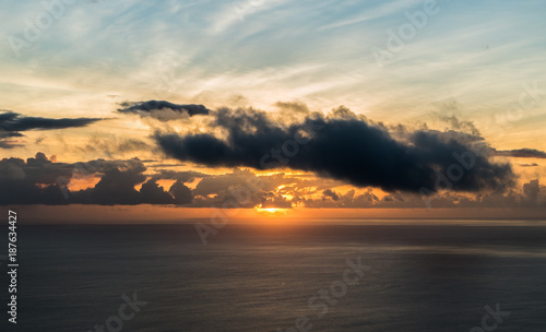 The sun and its last beams during a sunset on an island over the ocean