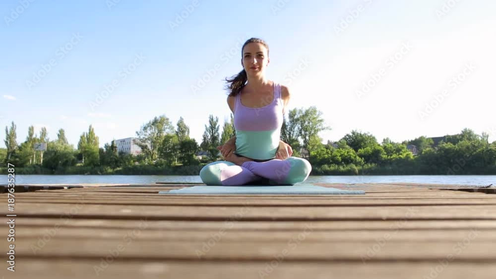 Flexible yoga teacher shows you a challenging exercise on wooden pier by the water, silhouette. Young girl is professionally engaged in yoga. Flexible yoga teacher shows you a challenging exercise on wooden pier by the water, silhouette. Young girl is professionally engaged in yoga.