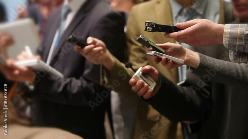 Group of unrecognizable journalists record interviews on dictaphones. Conceptual background image on theme of journalism and media.