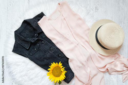 Black denim vest and peach chiffon cape. Hat and sunflower on white fur. Fashionable concept photo