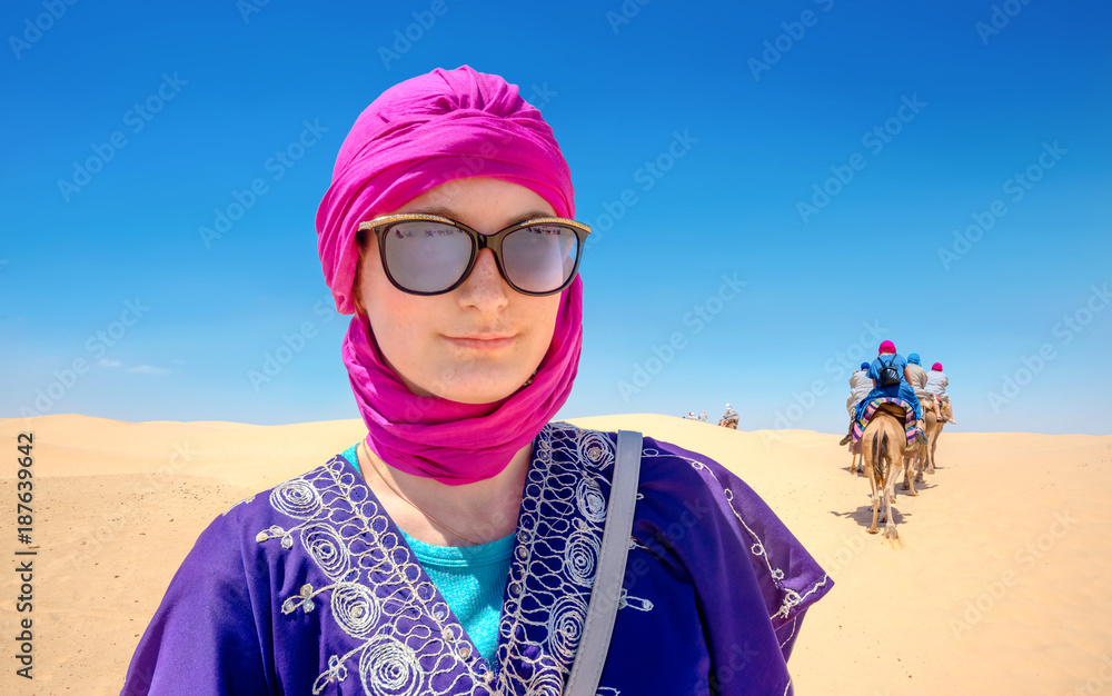 Beautiful woman in arabic traditional clothing against Sahara