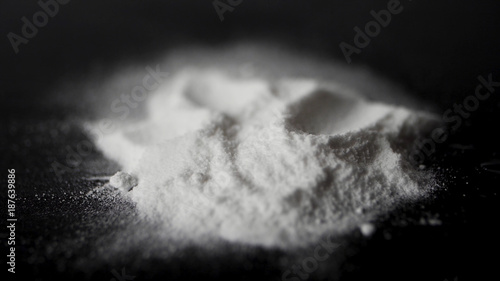 Фотография DRUGS: Man does a lines of heroin by plastic card - Close up