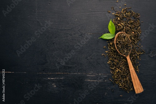 Dry green tea. On a wooden background. Top view. Copy space.