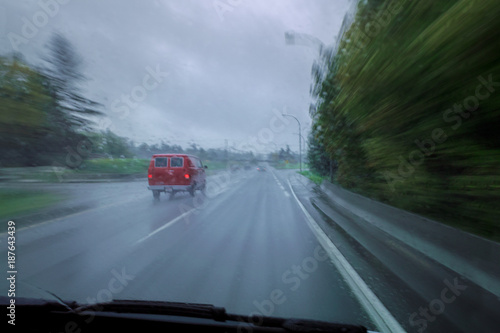 Roter Van auf verregneter Strasse aus dem verfolgenden Auto mit hoher Geschwindigkeit