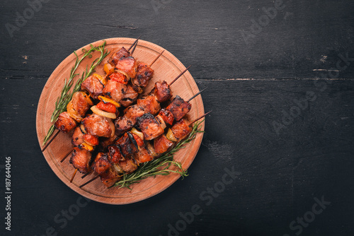 Shish kebab on skewers with onions. On the black wooden table.