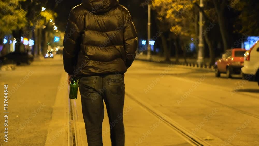 Drunk Man is Walking by the Night Street and Drinking Beer form the ...