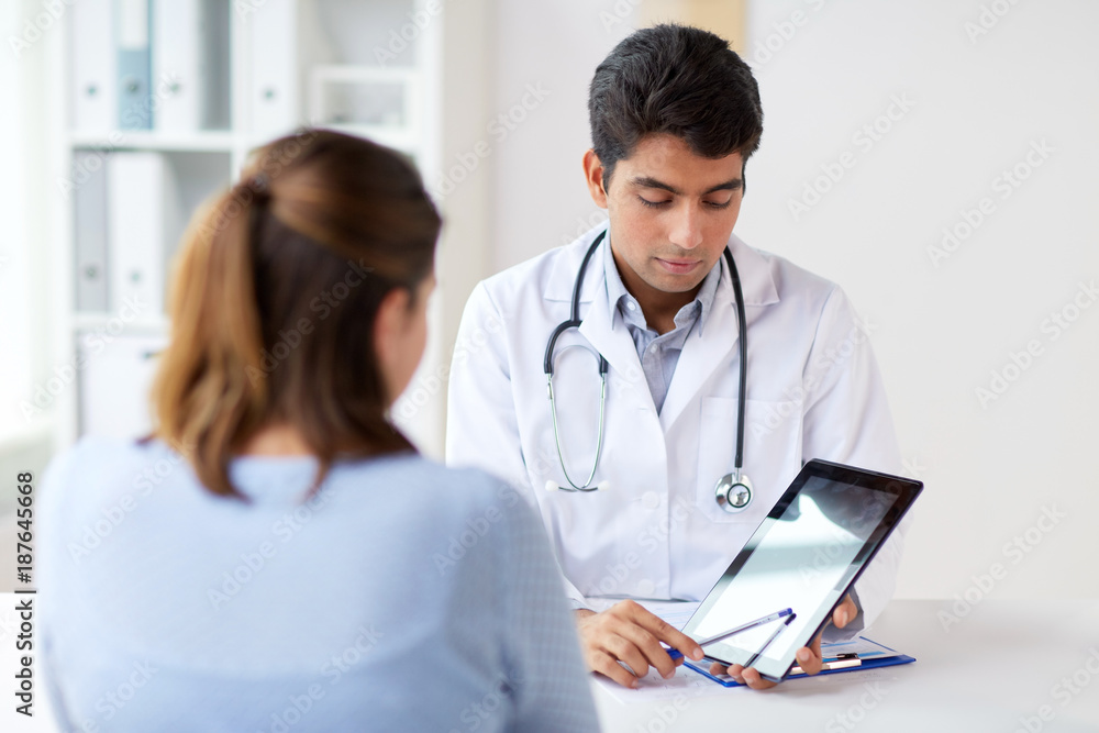 doctor showing tablet pc to patient at clinic doctor showing tablet pc to patient at clinic