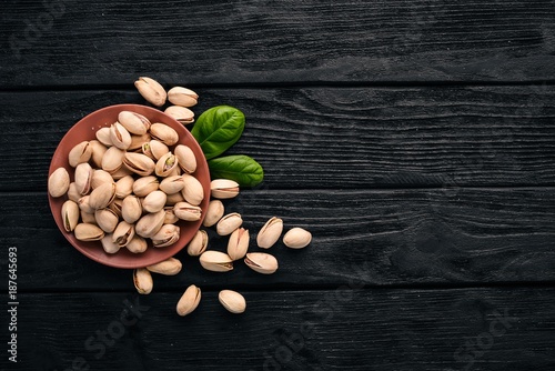 Pistachio nuts on a dark wooden background. Healthy snacks. Top view. Free space for text.