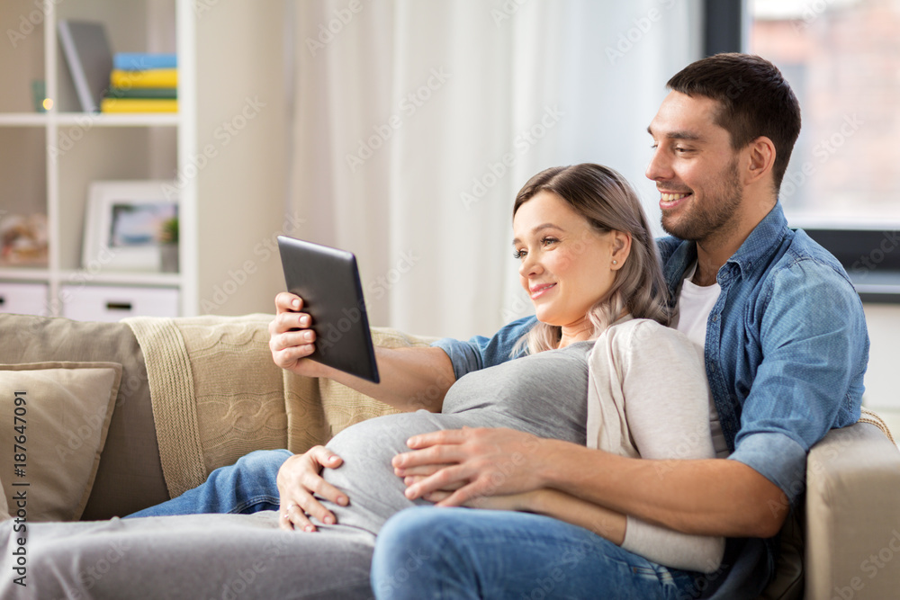 man and pregnant woman with tablet pc at home man and pregnant woman with tablet pc at home