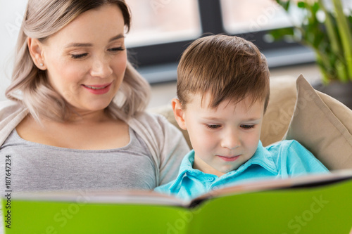 close up of happy mother and son reading book