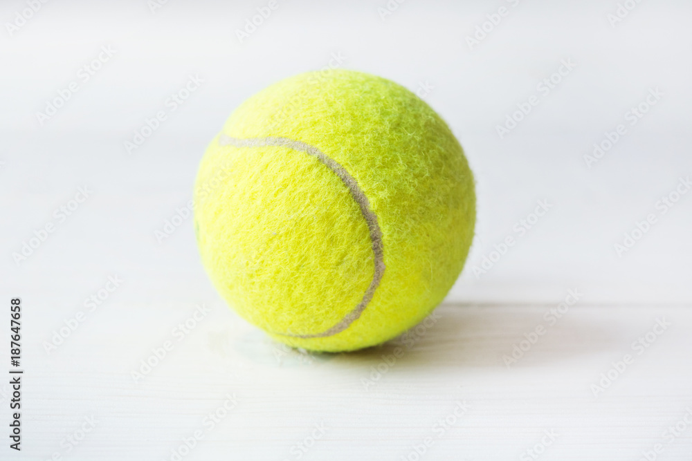 Close up of green tennis ball on a white background. Sport symbol of big tennis.