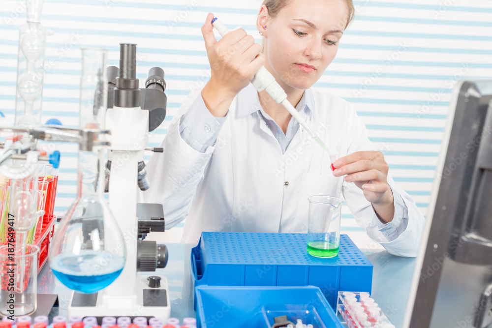 Experiments in the chemical laboratory, Female researcher using her test tube in a laboratory Experiments in the chemical laboratory, Female researcher using her test tube in a laboratory