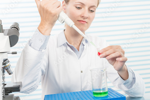 Experiments in the chemical laboratory  Female researcher using her test tube in a laboratory