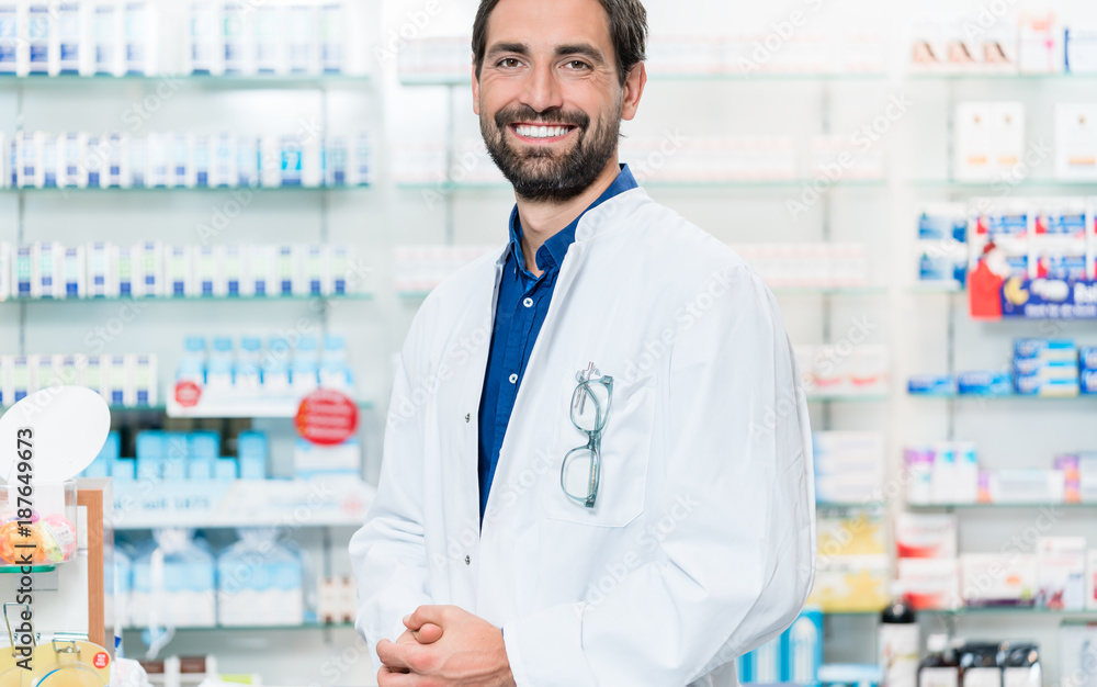 Apothecary in pharmacy store standing at shelf with drugs