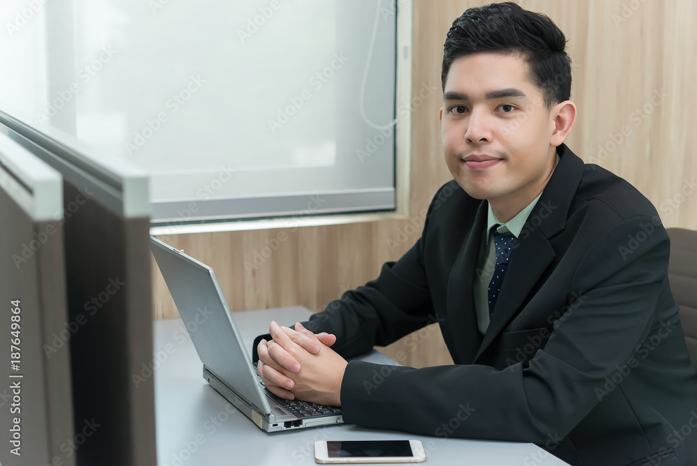 Young asian employee working at laptop during working day in office,Businessman happy with smile in the office,thailand people at company Young asian employee working at laptop during working day in office,Businessman happy with smile in the office,thailand people at company