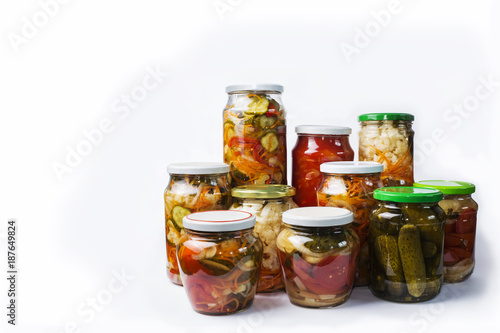 Glass jars with different colorful canned salads isolated on white background with place for text