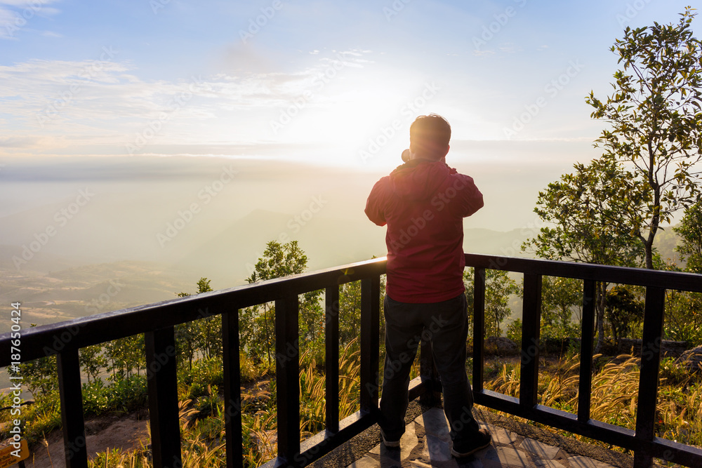 Back view of a photographer taking photo of beautiful mountain at sunrise landscape with dslr camera Back view of a photographer taking photo of beautiful mountain at sunrise landscape with dslr camera