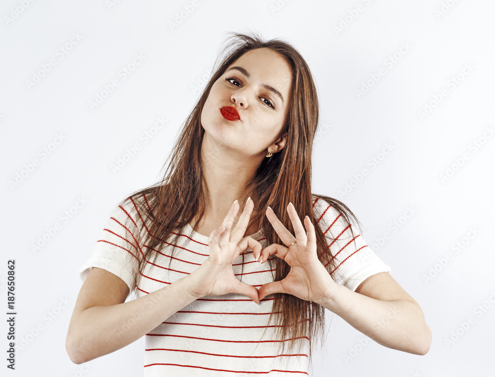 A teenage girl holds her hands like a heart. A teenage girl holds her hands like a heart.