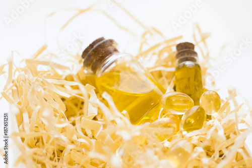 Natural cosmetics concept, essential oil in glass bottles in a yellow filler, white background, close up