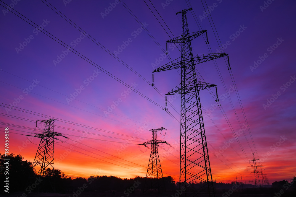 High-voltage power lines during fiery sunrise