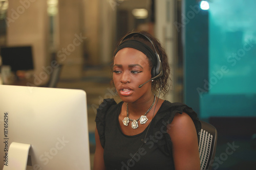 Puzzled woman in headset looking at monitor