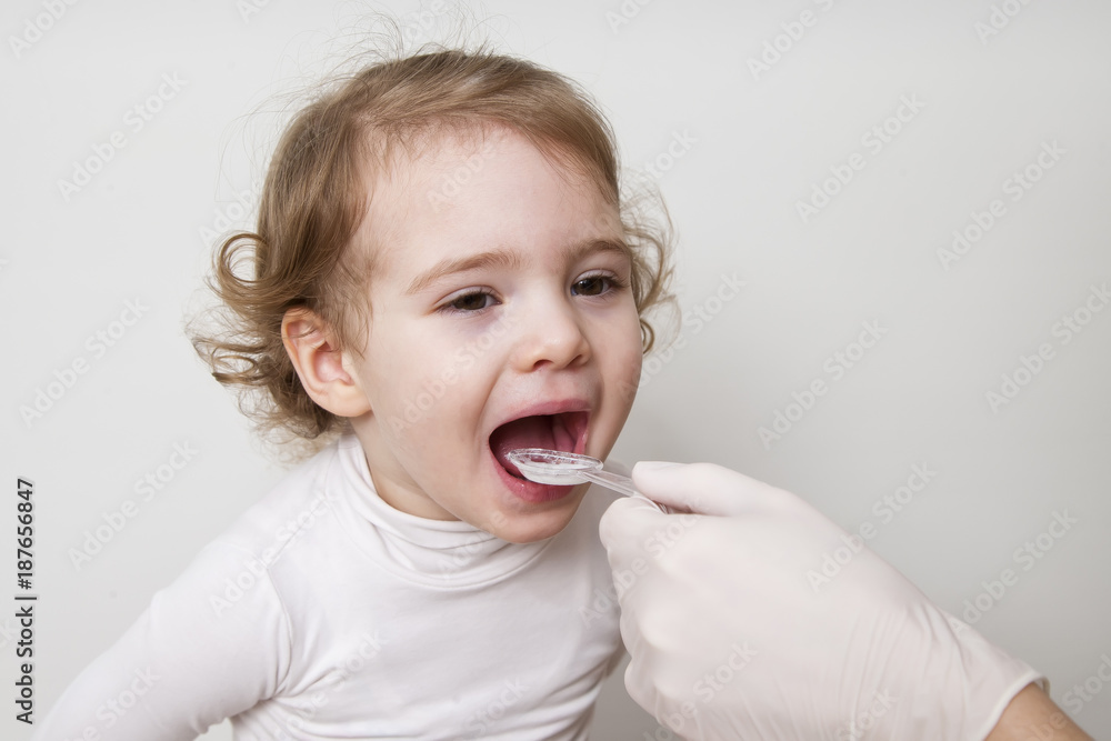 Little girl taking medicine with spoon Little girl taking medicine with spoon