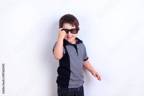 Cute funny little boy wearing sunglasses, studio shoot on white. Lifestyle, children concept