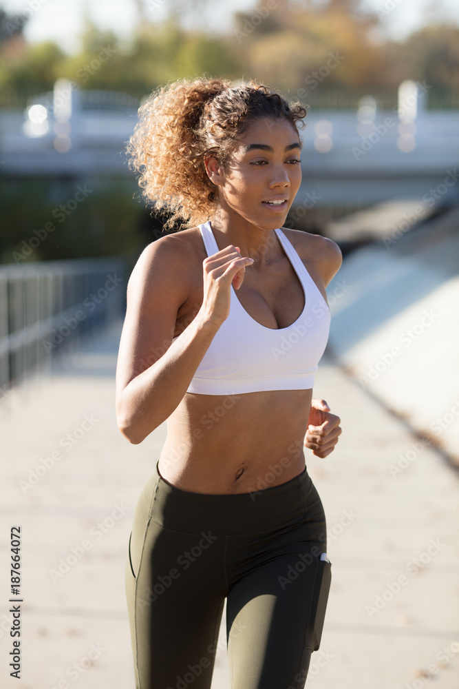 Girl running in white sports bra Stock Photo