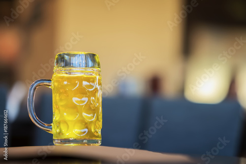 Fototapeta Glass mug of golden light beer in bar, in pub close up