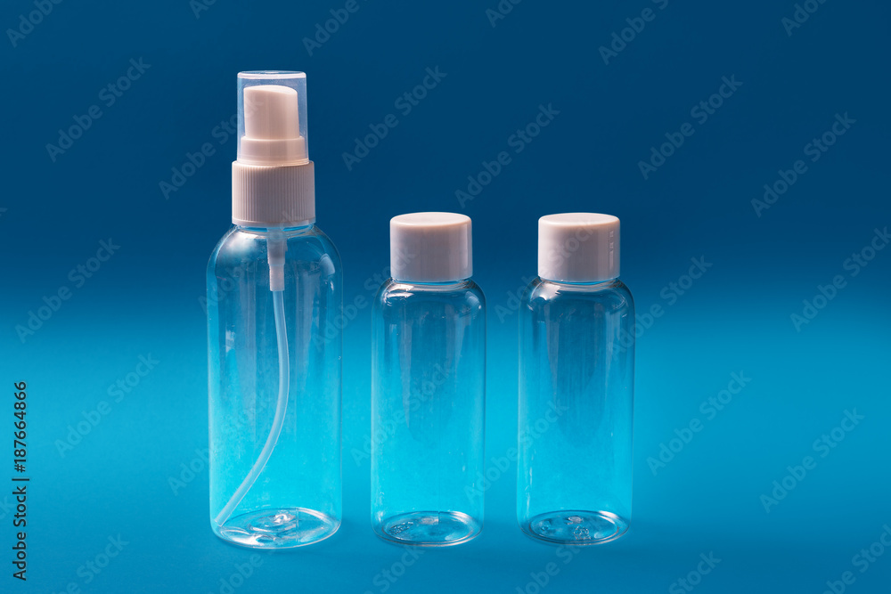 Set of empty travel bottles, blue background Set of empty travel bottles, blue background