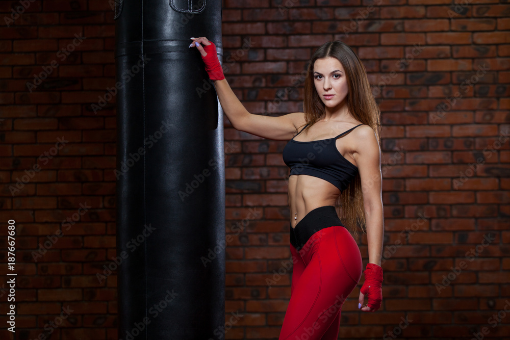 Young women boxing, the boxing bag. red bandage on hands