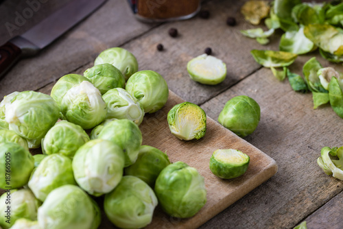 Brussels sprouts on wooden cutting desk on rustic table.