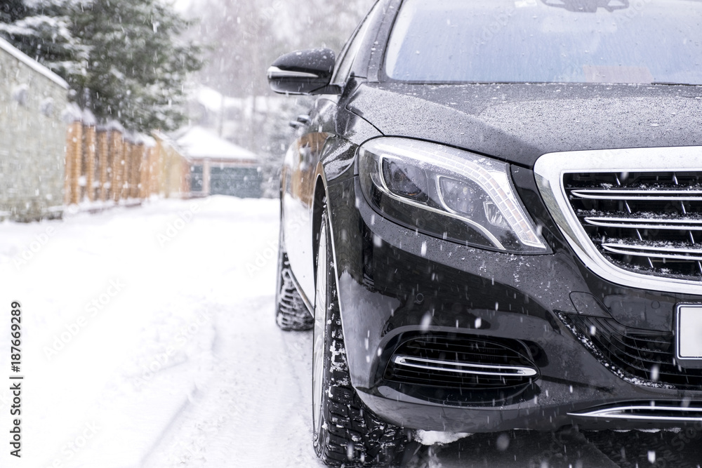 Fototapeta premium Car on Snowy road in snowfall