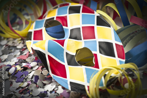 Carnival mask on colorful confetti and streamer background