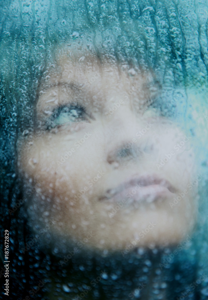 Sad young woman and a rain drops.