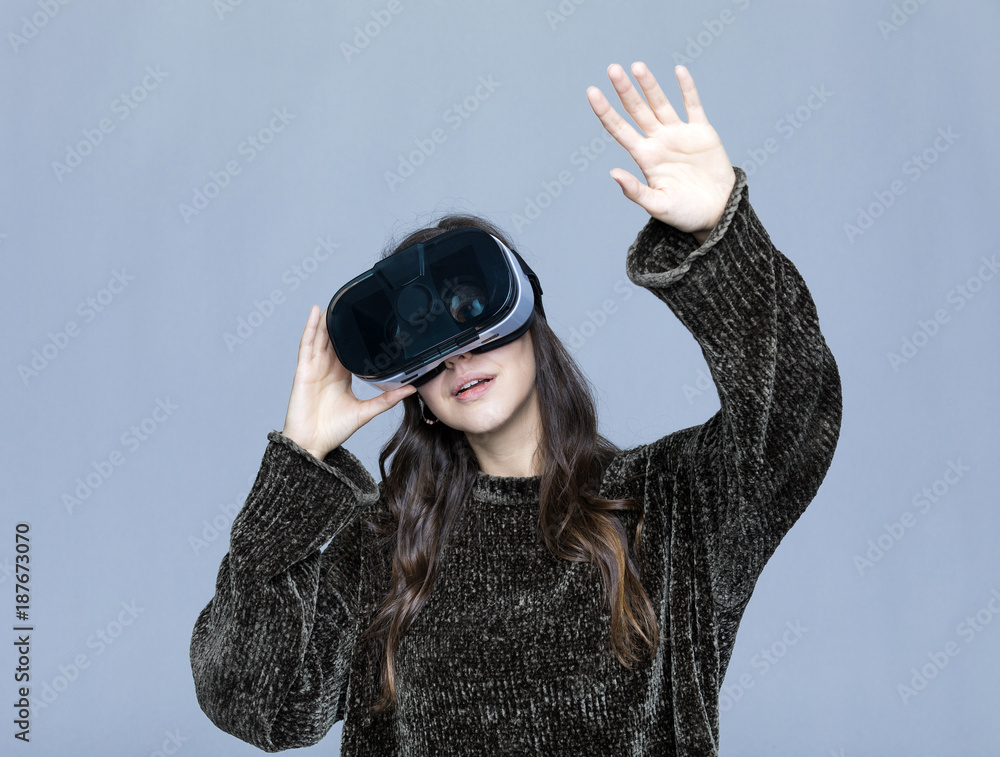 Beautiful young woman touching air during the VR experience