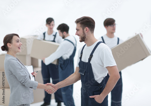 Manager with clipboard shaking hands with movers.