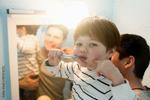 Young father with his son brushing teeth
