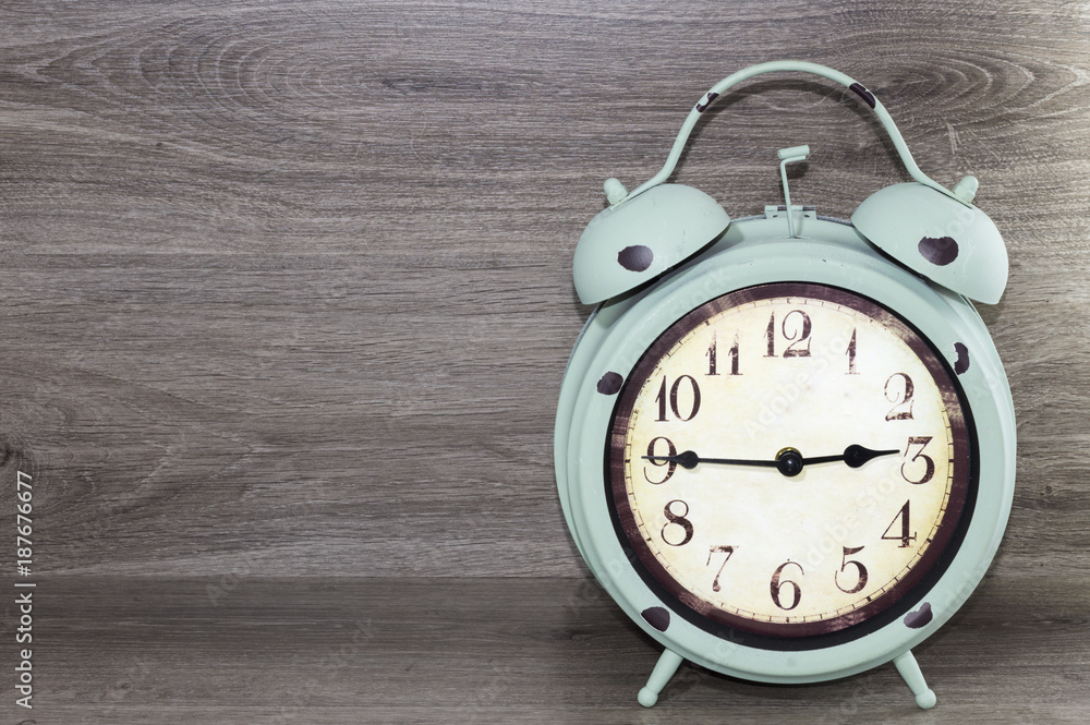 Antiguo reloj despertador, a las dos horas y cuarenta y cinco minutos,  sobre un fondo de madera gris Stock Photo | Adobe Stock