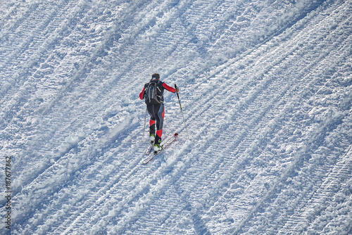 Skier climb on skis and sealskins.The ski slope and skiers at Passo Groste ski area ,italy photo