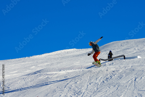 MADONNA DI CAMPIGLIO, ITALY-21 November 2014:Ski and snowboard riders ride down a ski slope in Madonna di Campiglio mountain ski resort on snowy winter mountain scenic background